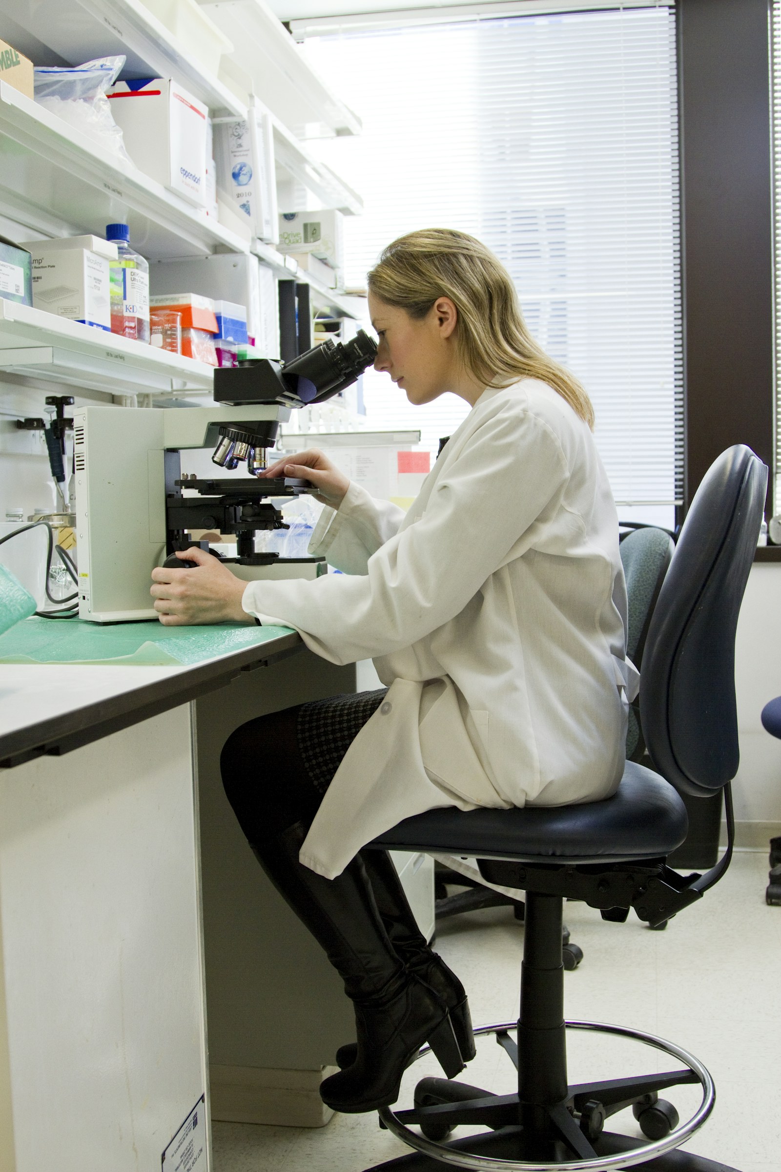 Researcher reviewing a specimen through a microscope